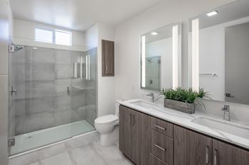 Hand-set tile showers with glass door enclosures